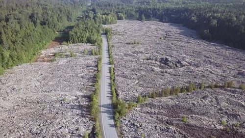 Aerial follows road built through lava field volcanic debris, geology