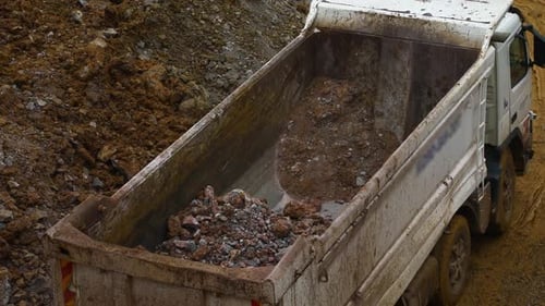 Bagger füllt Muldenkipper