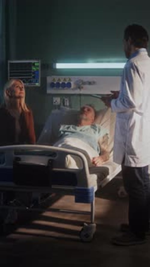 Experienced Doctor Talks to Elderly Patient and Woman in Ward