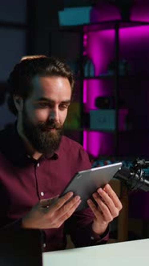 Young Man Reviewing Flexible Tablet at Desk