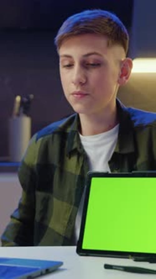 Focused Teenager Sit at Desk Makes Videocall Conference Speech and Showing Green Screen Digital