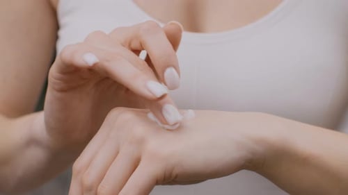 Woman Applies Moisturizing Cream to Hand