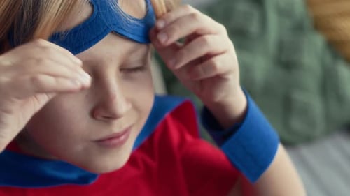 Close Up of Boy in Blue Superhero Eye Mask Looking at Camera