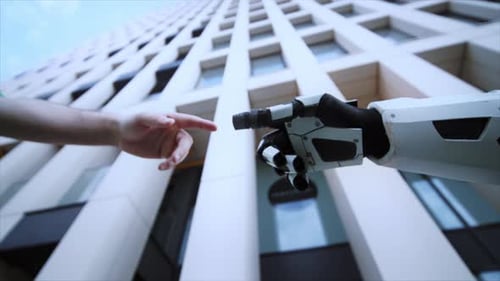 Shot From Below of Robot Hand and Man's Hand Pointing Fingertips Outdoors Blurred View of Modern