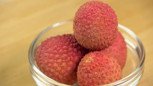 Frische Litschifrüchte in der Schale rotieren in einer Glasschale im Makro. Litschibeeren für die Herstellung
von Limonade