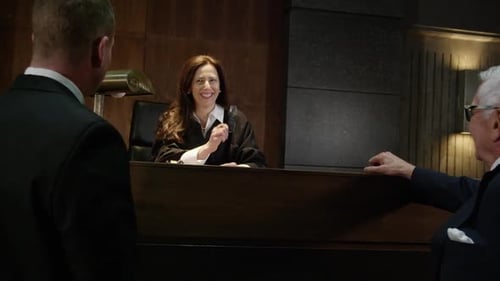 Judge smiling and laughing in court with lawyers HD