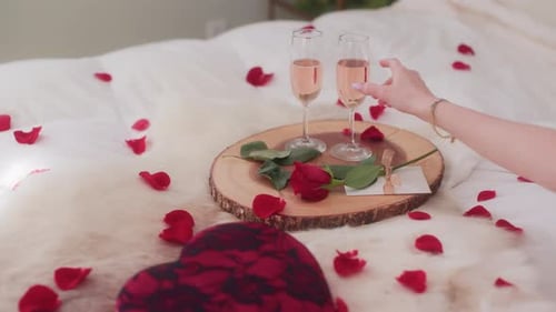 Romantic Champagne and Rose Petals on Bed