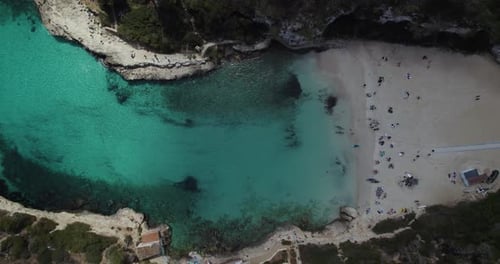 Cove Turquoise Beach Of Cala Llombards During Dayrime In Mallorca, Spain. aerial top-down