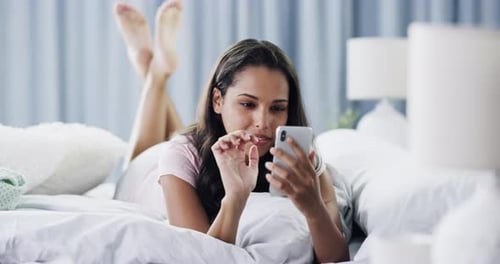 Woman Using Smartphone on Bed in Bright Room
