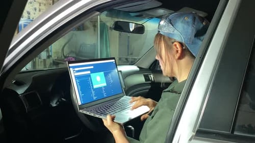 Young Female Mechanic Performs Computer Car Diagnostics