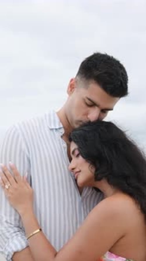 Affectionate young couple hugging tenderly at the beach