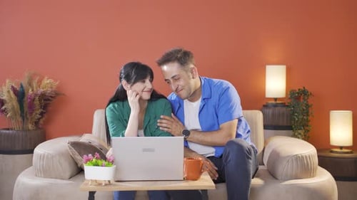 Happy Couple Using Laptop Together at Home