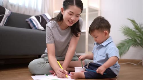 Mother and Child Drawing Together on Floor at Home