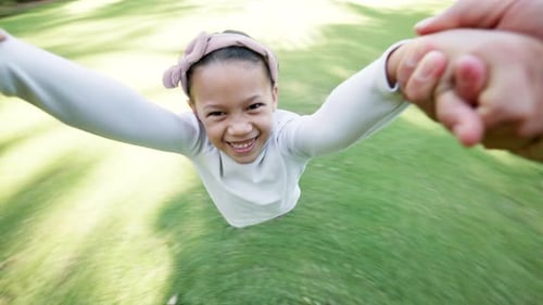 Visage, sourire et fille filant dans le jardin avec ses parents pour l'amour, le plaisir ou la création de liens en famille