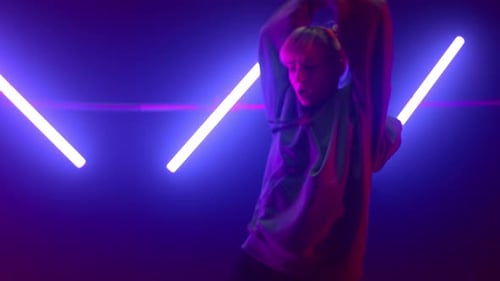 Expressive blonde dancer moving hands energetic in nightclub ultraviolet lights