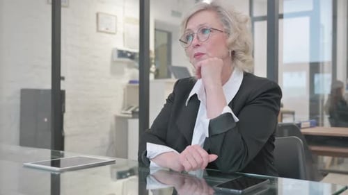 Pensive Old Businesswoman Sitting in Office