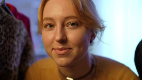 Manteaux de fourrure en gros plan suspendus sur une étagère avec une belle femme mince et joyeuse apparaissant en regardant la caméra