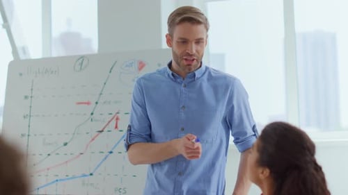 Male Leader Brainstorming With Creative People In Modern Office. Smiling Business Man Talking Wit...