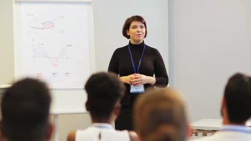 Woman Gives Presentation to Audience in Meeting Room