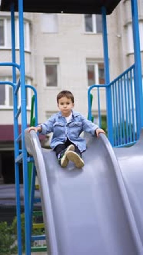 Boy on a Playground Slide Having Fun