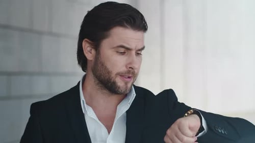 Closeup Worried Business Man Checking Time on Wristwatch in Modern City. Portrait