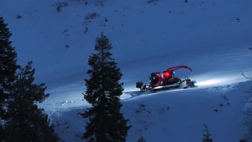 Night Drone Close Up of Snow Groomer on Ski Slope