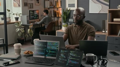 African American Software Engineer Typing on Laptop during Workday in Office