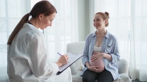 врач-гинеколог объясняет что-то беременной женщине в кабинете