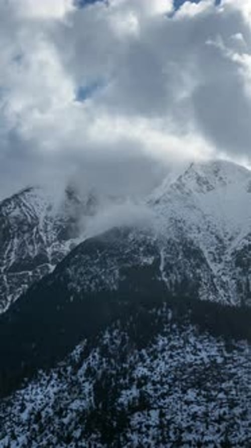 Snowy Mountain Peaks Under Cloudy Winter Sky