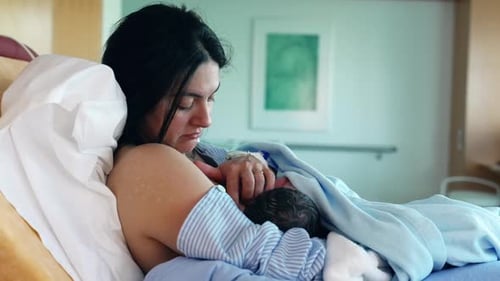 Intimate Post-Delivery Bonding - New Mother Feeds Newborn in Hospital, Highlighting First Moments