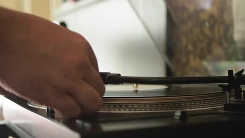 Close up of the stylus getting put onto the record. Men start playing vinyl record. Put the needle o