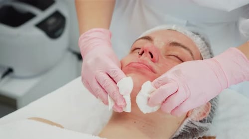 Cosmetologist Wiping Client Face During Skincare Procedure Professional Removing Remaining Mask with