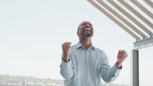 Happy african american businessman celebrating at office, slow motion
