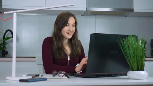 Excited Woman Celebrates Success While Working on Laptop