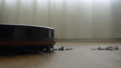 Robotic Vacuum Cleaner Gathers Dust on Wooden Floor