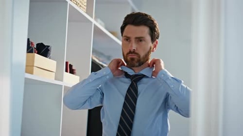 Man Tying Necktie in Dressing Room
