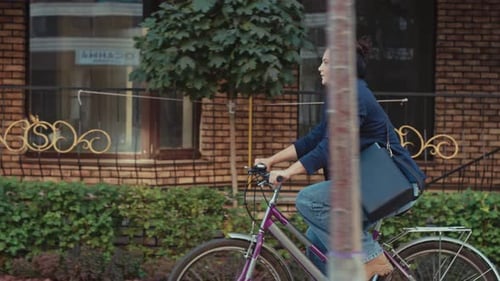 A Businesswoman Rides a Bicycle to the Office of the Business Center