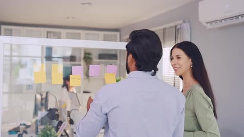 Two young professional businessman and businesswoman working in office.