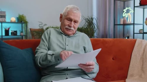 Senior Man Reads Documents and Gives Approval