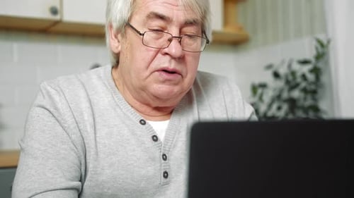 Senior Man Using a Laptop at Home