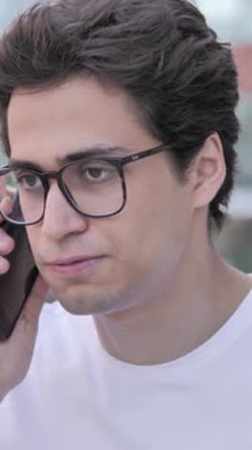 Porträt eines wütenden Mannes, der am Telefon schreit, vertikales Video