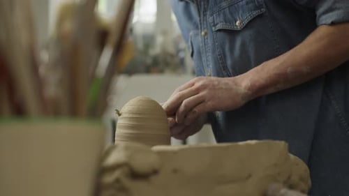 Closeup of the Hands of a Ceramist Making Clay Products in a Workshop on Table