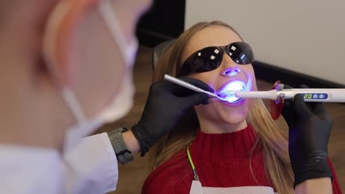 Remplissage composite durcissant par un dentiste à la lumière ultraviolette