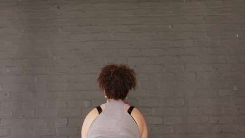 Medicine ball tossing upward and striking brick wall before rebounding into catch, in training