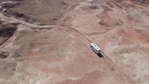 An aerial shot of an Rv driving off-road through the Utah desert on an American roadtrip.
