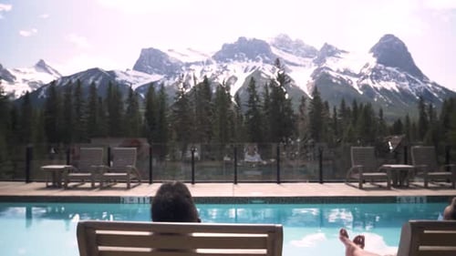 Couple Lying on Pool Loungers with Mountain View Adult