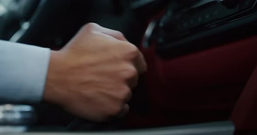 Close up young businessman is driving a new anonymous car just bought from auto deal. Slow motion