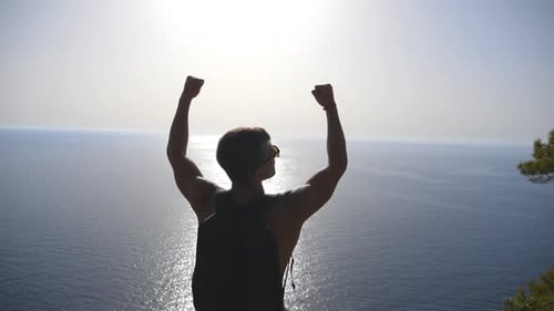 Triumphant Hiker Arms Raised Overlooking Ocean