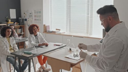 Science Teacher Conducting Chemistry Experiment for Students