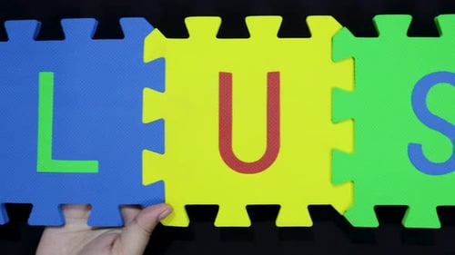 hands displaying blue yellow green tiles with LUST word for learning theme